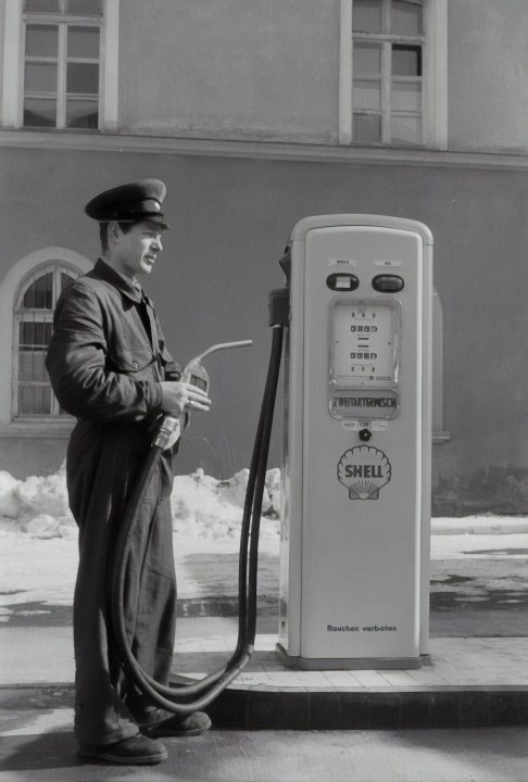 Gas station attendant at the petrol pump. 1955