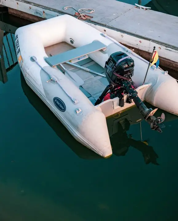 A small inflatable boat sits in the quiet harbor