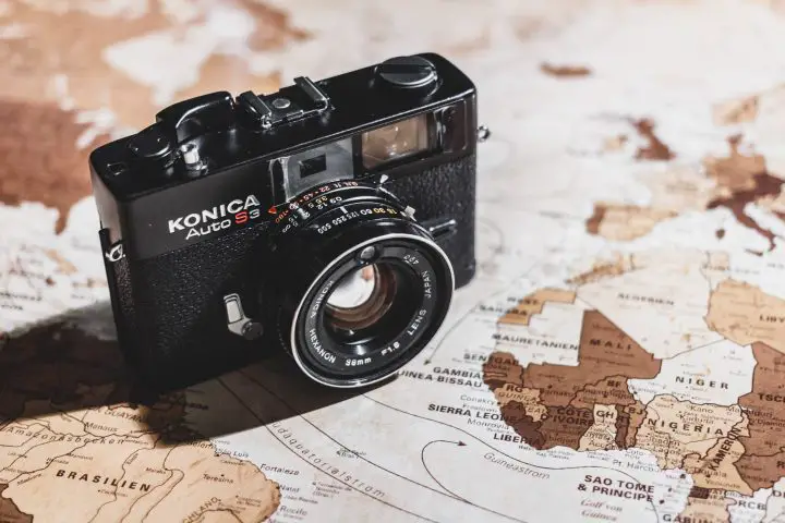 Black vintage camera on a brownish map